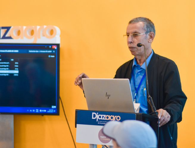 Intervenant à l'Agora des Experts lors du salon Djazagro, présentant un sujet professionnel avec un ordinateur portable sur un pupitre."