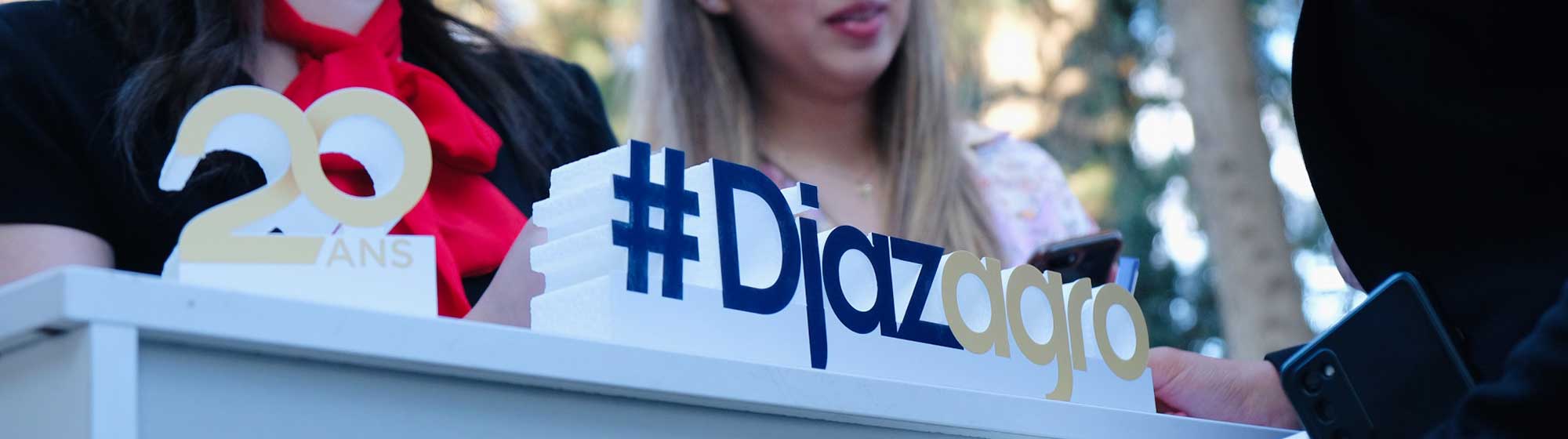 Two hostesses behind the Djazagro 20th edition logo