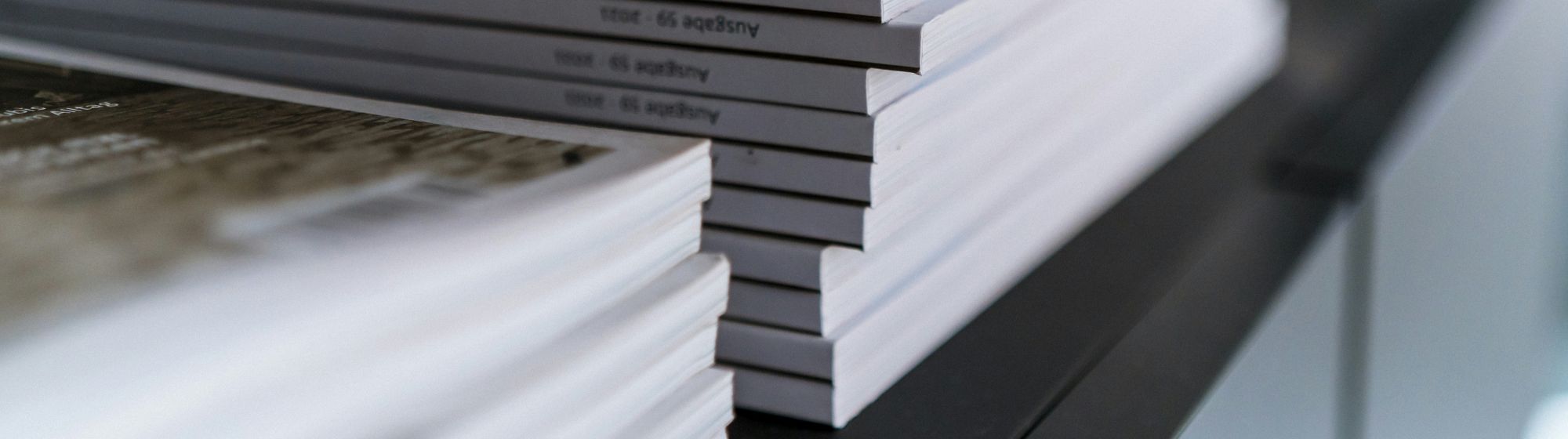 Stack of brochures or documents neatly arranged, representing press releases or professional publications.