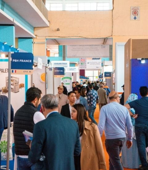 View of a busy aisle at the Djazagro trade show with many visitors walking between exhibitor booths.