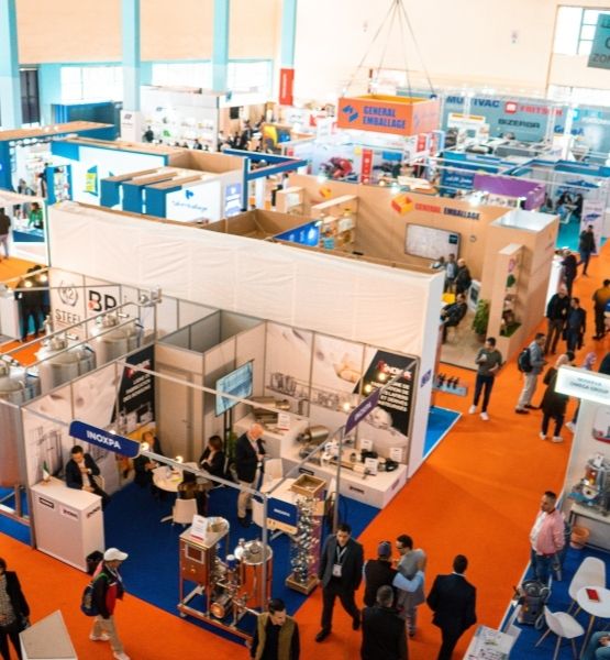 Overview of a professional trade show with exhibitor booths and visitors moving around.