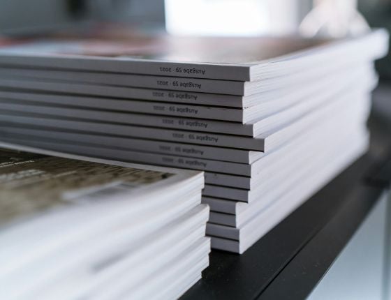 Pile de brochures ou documents alignés, symbolisant des communiqués de presse ou des publications professionnelles